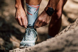 Man tying his shoe laces wearing Performance Sky Sox Footwear.