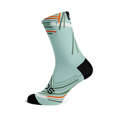 Performance Sky Crew Length Sock. Light blue background with geometric stripes of oranges, shades of green and white strikingly placed on the sock.