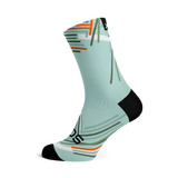 Performance Sky Crew Length Sock. Light blue background with geometric stripes of oranges, shades of green and white strikingly placed on the sock.